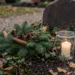 Gepflegtes Grab im November mit Tannengesteck und brennendem Grablicht