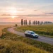 Ритуальний автомобіль на дорозі між пшеничним полем і соняшниками