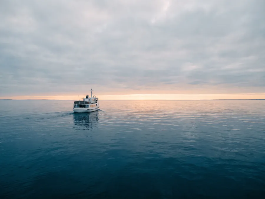 Kleines Schiff auf ruhiger See im Abendlicht