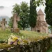 Friedhof mit Steinkreuzen und kleiner Kirche vor Berglandschaft im Kaukasus im Morgenlicht