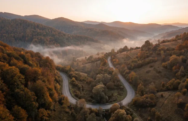 Überführung aus Ungarn, der Slowakei und Rumänien in die Ukraine - RITUAL-SERVICE24 Kurvige leere Bergstraße durch herbstliche Wälder der Karpaten mit Nebel in den Tälern
